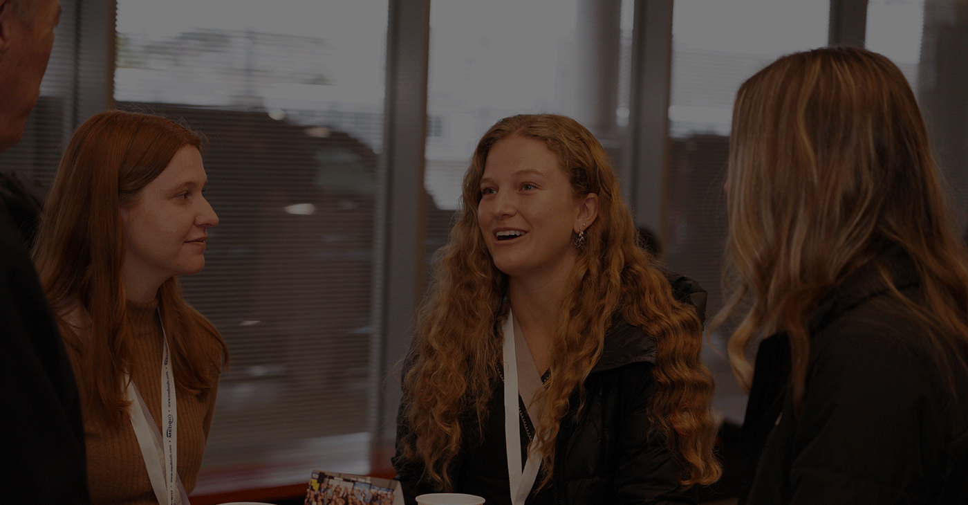Three business women having holding cups having a conversation